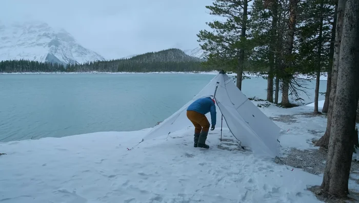 Choose a protected campsite and set up a solid tent to block wind.