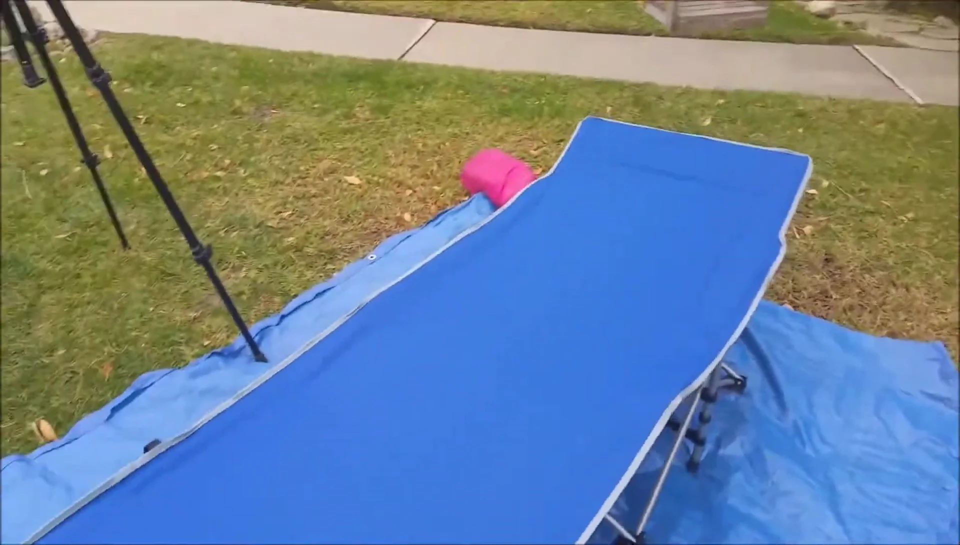 The reviewer sits on the cot, demonstrating its stability.