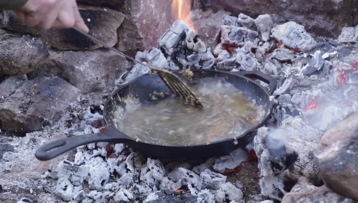 Once the water is hot, scrub the skillet with a brush to remove stuck-on food.