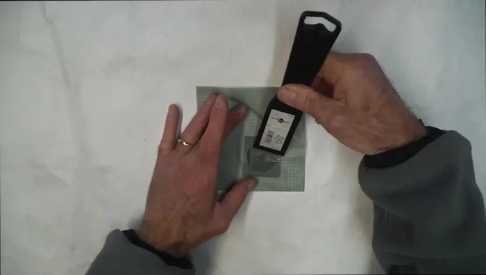 Use a putty knife or credit card to smooth out excess silicone and press the patch firmly.