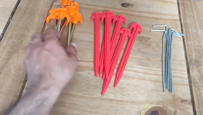 Introduce better alternatives: Show different types of pegs: standard metal, slightly longer metal, plastic, and heavy-duty metal.