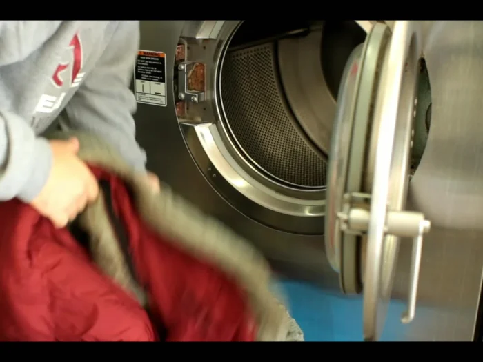 Carefully remove the sleeping bag from the washer, supporting its weight to prevent damage.
