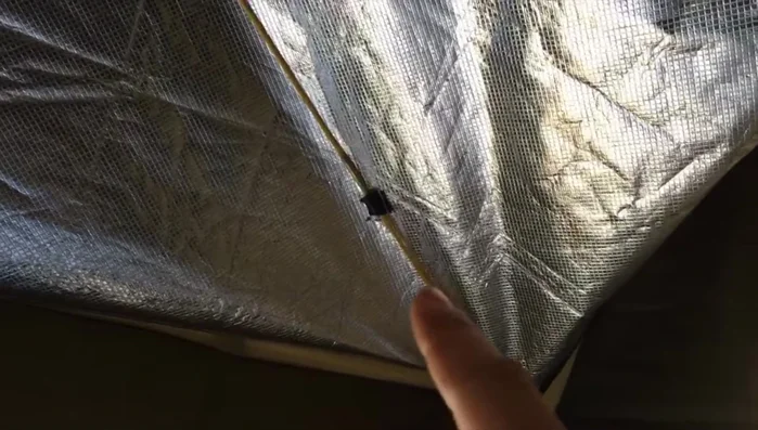 Use a strap or similar fastener to pull the center of the pole structure upwards, creating an arched shape to maximize space and prevent sagging.