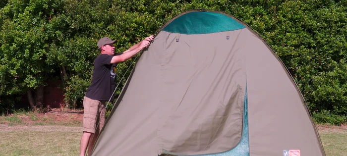 Stand in the doorway, pull down the center of the tent, and remove remaining clips.