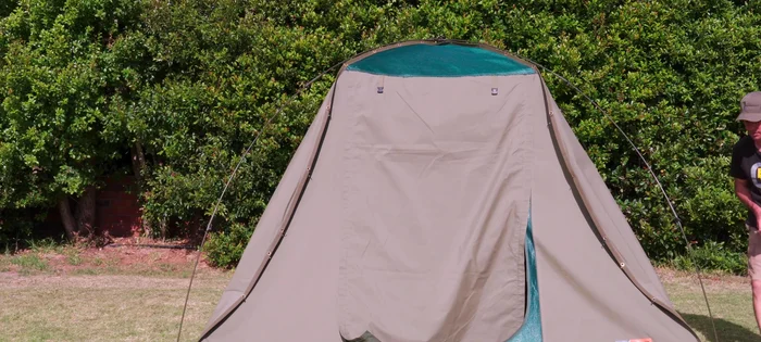 Stand in the doorway, pull down the center of the tent, and remove remaining clips.