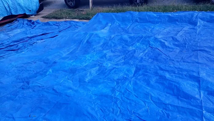 Pre-rinse the tarp with water to remove loose dirt and mud.