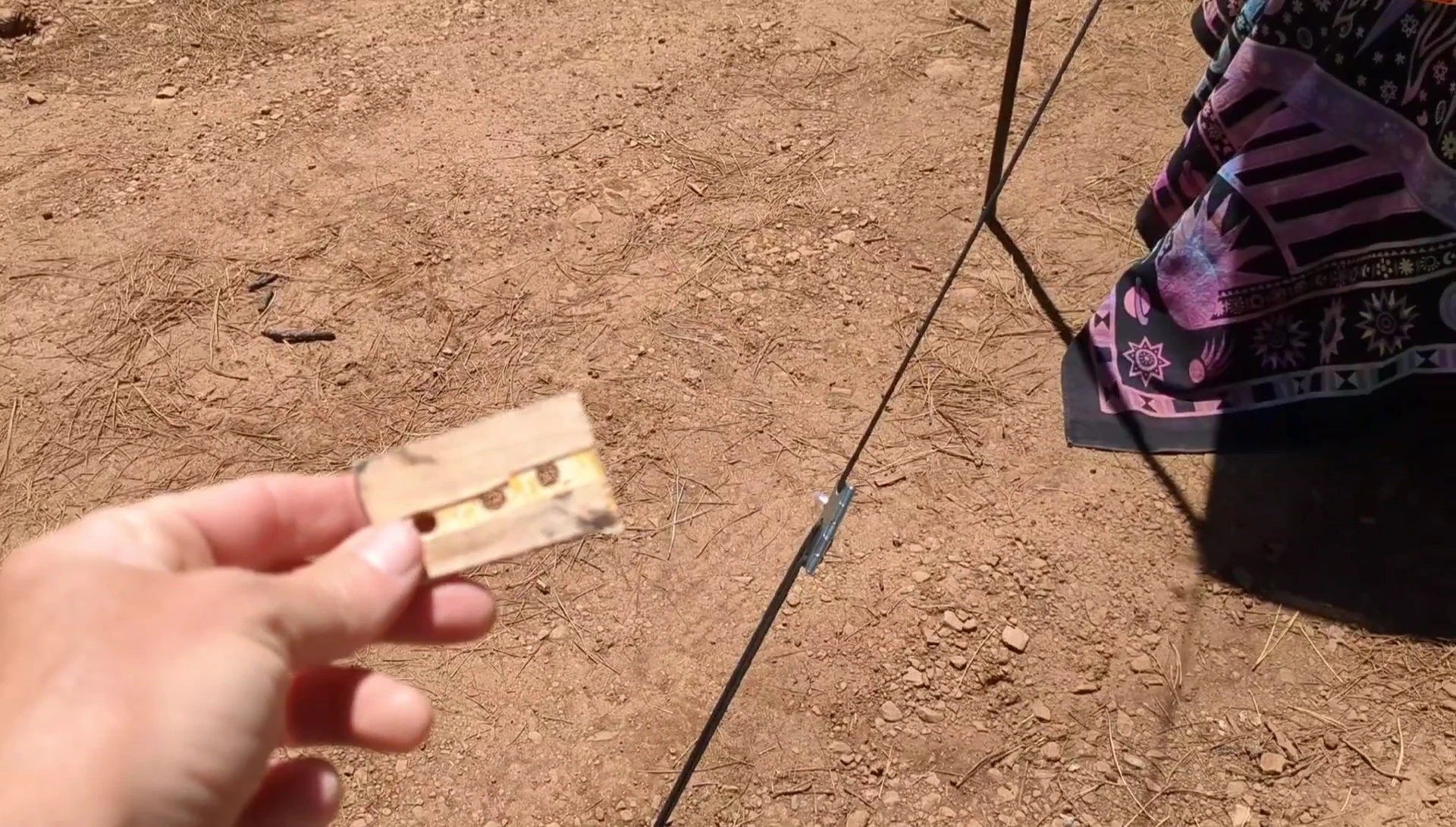 The wooden cleat being removed from the paracord.