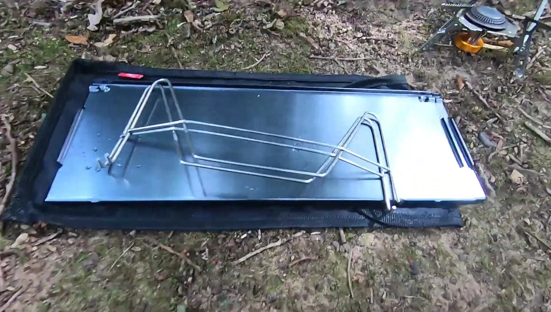 The folded table being put into its carrying bag