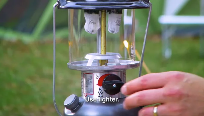 Light the lantern by pushing a lit match through the lighting hole and turning the fuel valve to 'high'. If fire appears outside the mantles, there's a leak; turn the fuel valve off immediately.