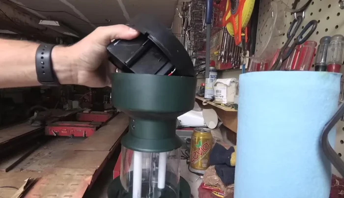 Carefully pry the battery pack from the base. It's held in place by adhesive. Use a flat object to pry gently from behind, avoiding damage to the lantern.