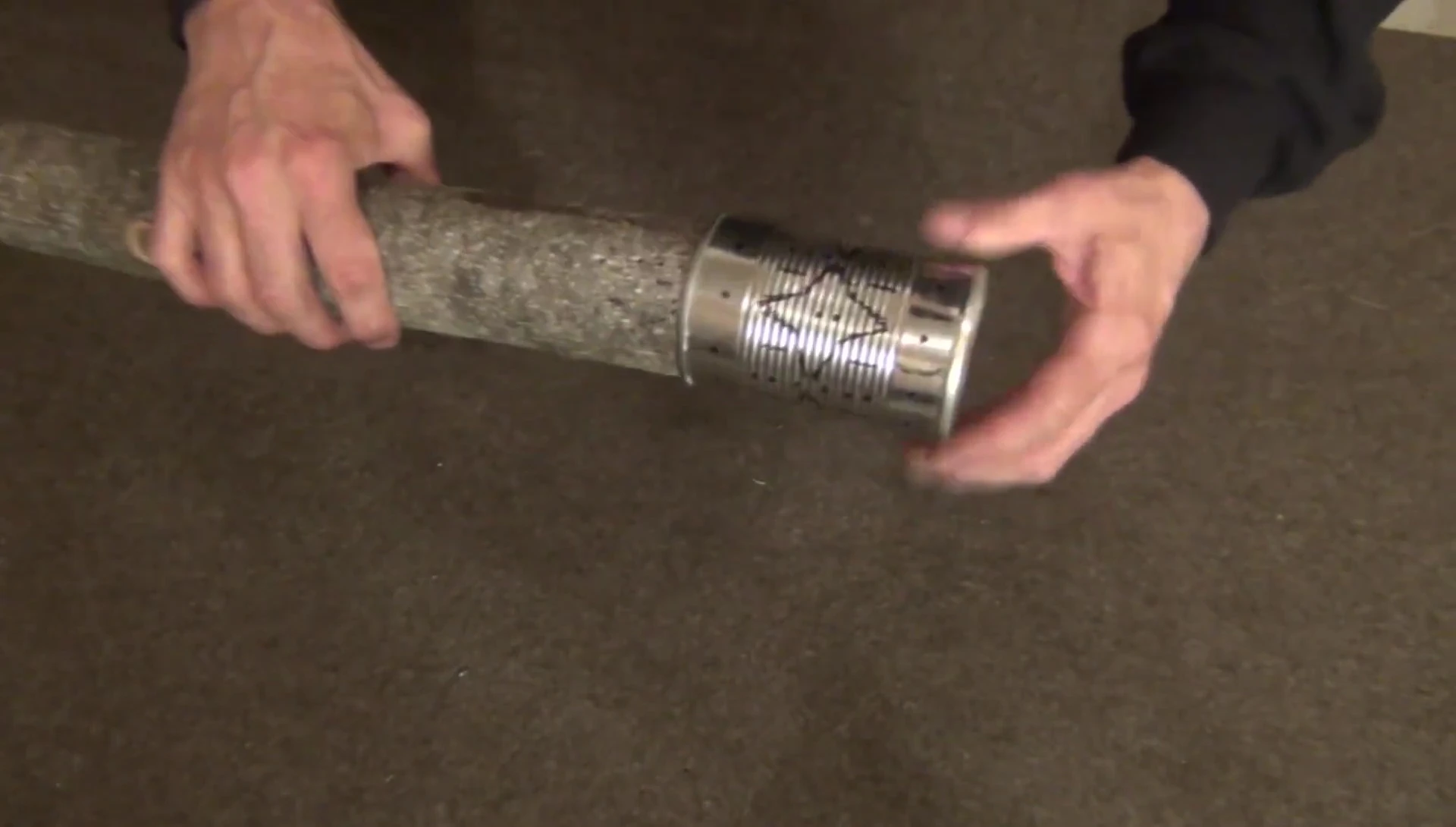 Inserting the wooden dowel into the tin can.