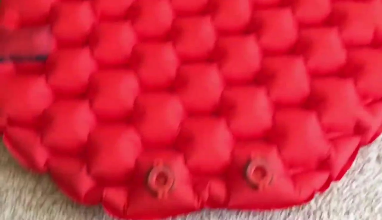 Person inflating the sleeping pad with a pump bag.