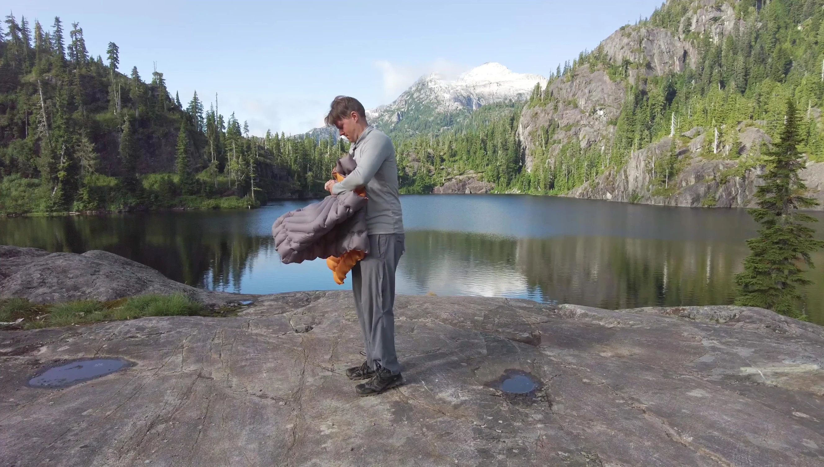 The reviewer demonstrating the ease of packing the sleeping pad into its stuff sack.