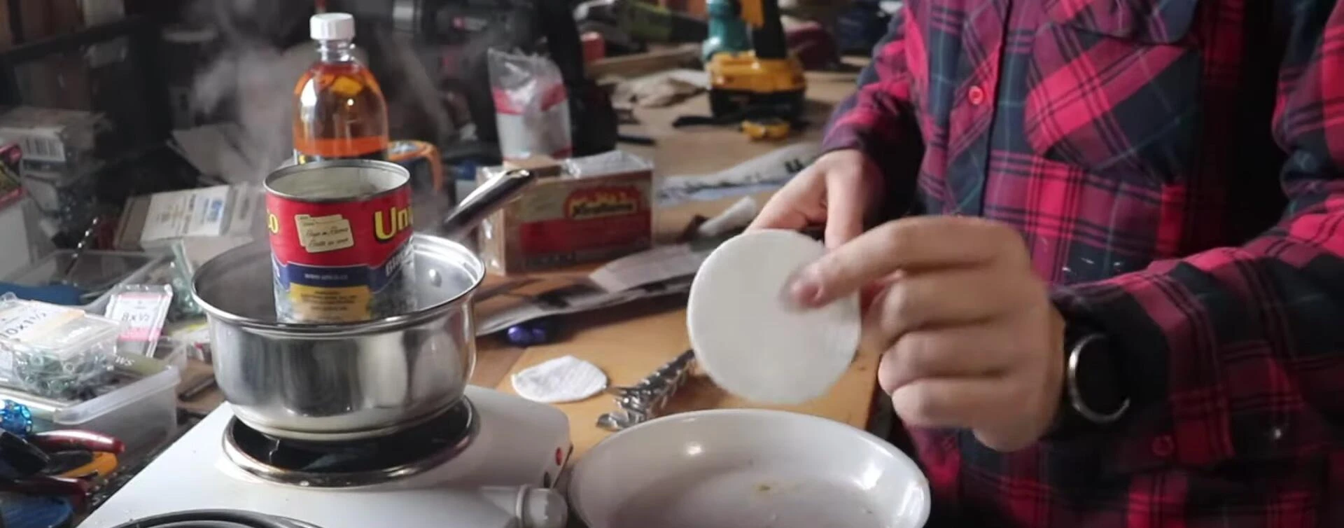 Cotton pad being dipped into the melted paraffin wax.