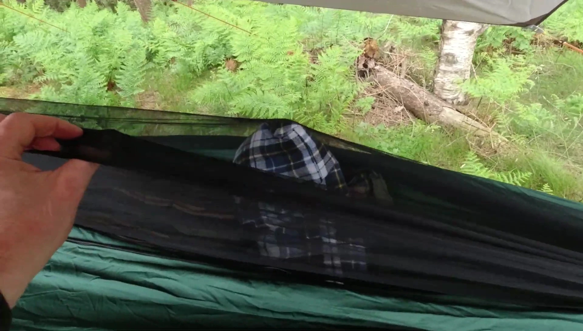 The hammock net hanging unevenly on the reviewer.