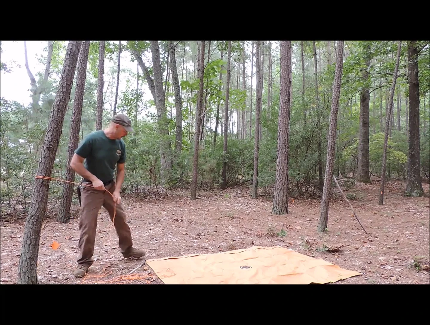 The reviewer threading the cordage through the tarp grommets.