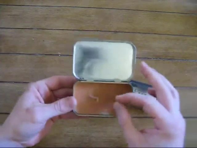 A detailed view of the paperclip used to secure and straighten the wick.