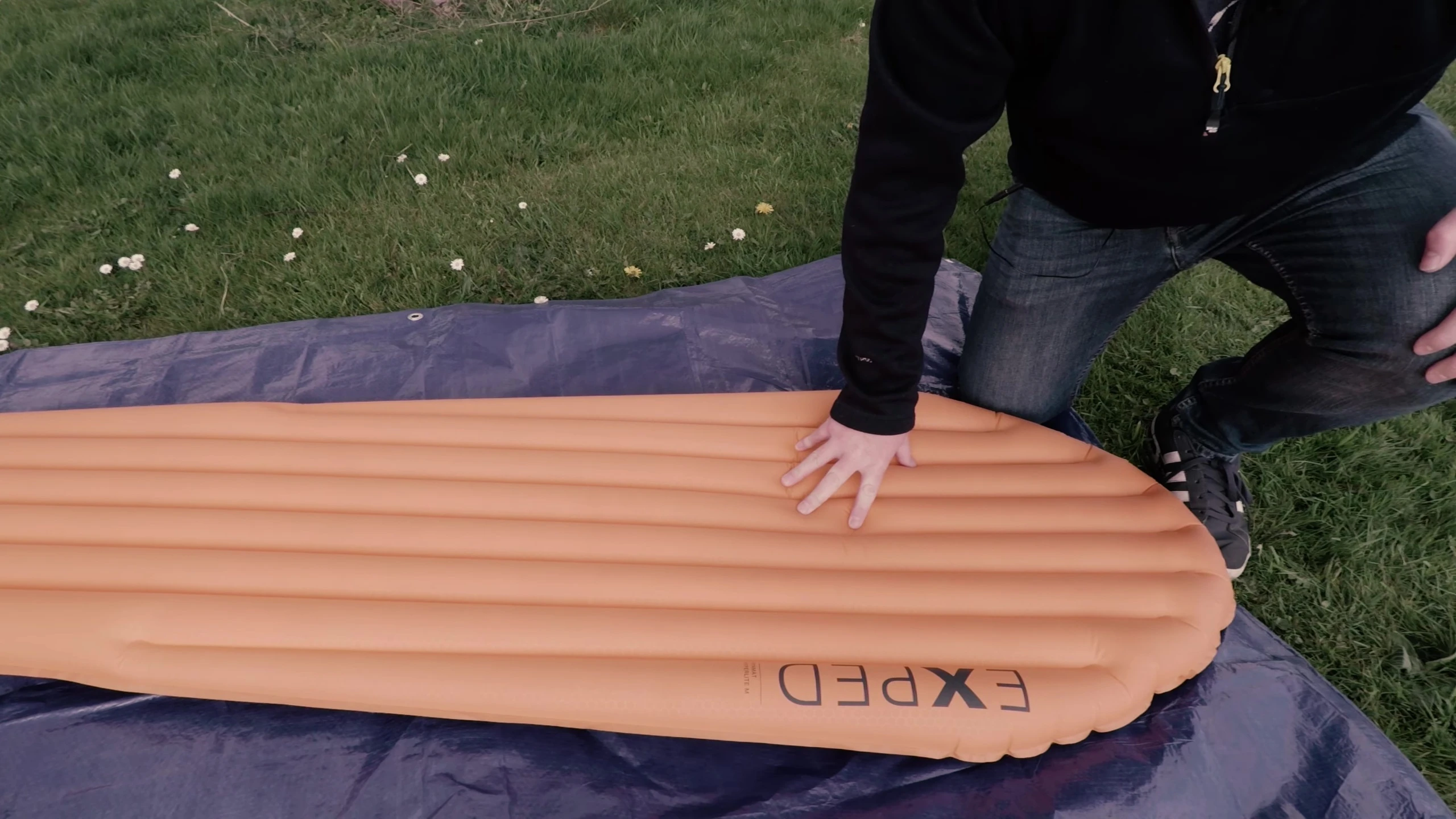 The reviewer demonstrating the size and dimensions of the sleeping pad.