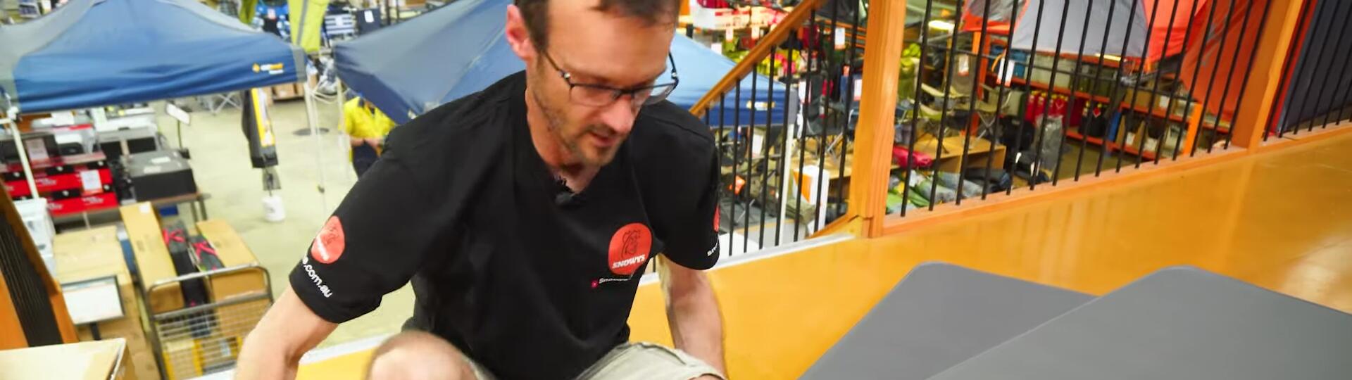 Image of a person sitting on the Coleman High Peak camp mat.