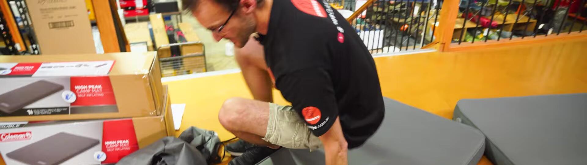Image of a person demonstrating the firmness of the mat by pressing down.