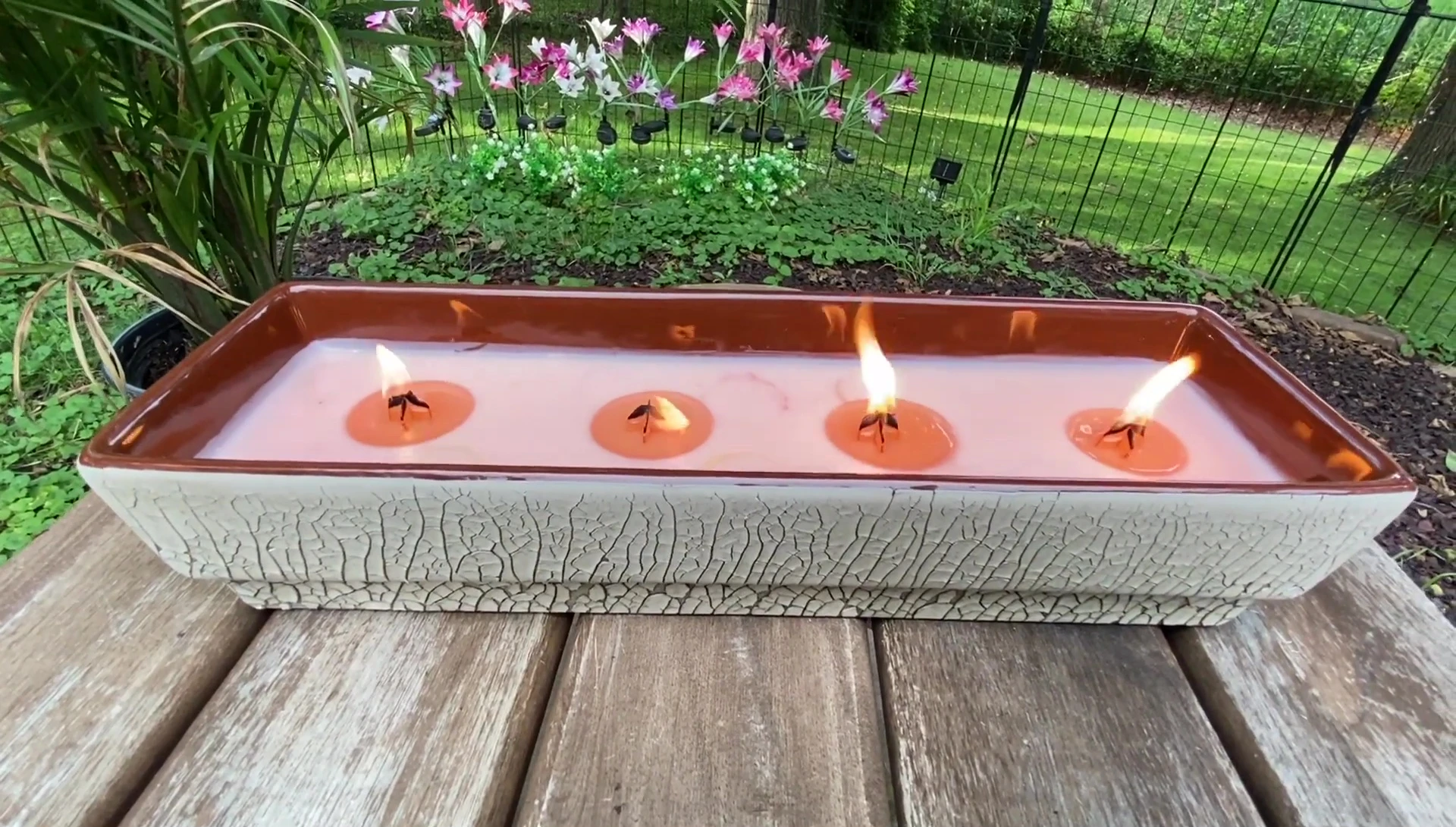 Wide shot of the candle burning on the patio