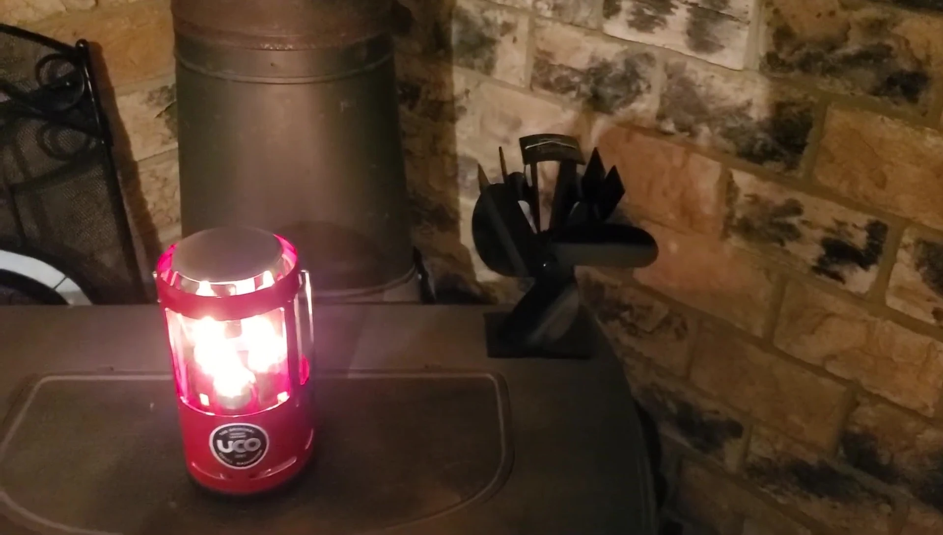 Placing the wood stove fan on top of the lit UCO candle lantern.