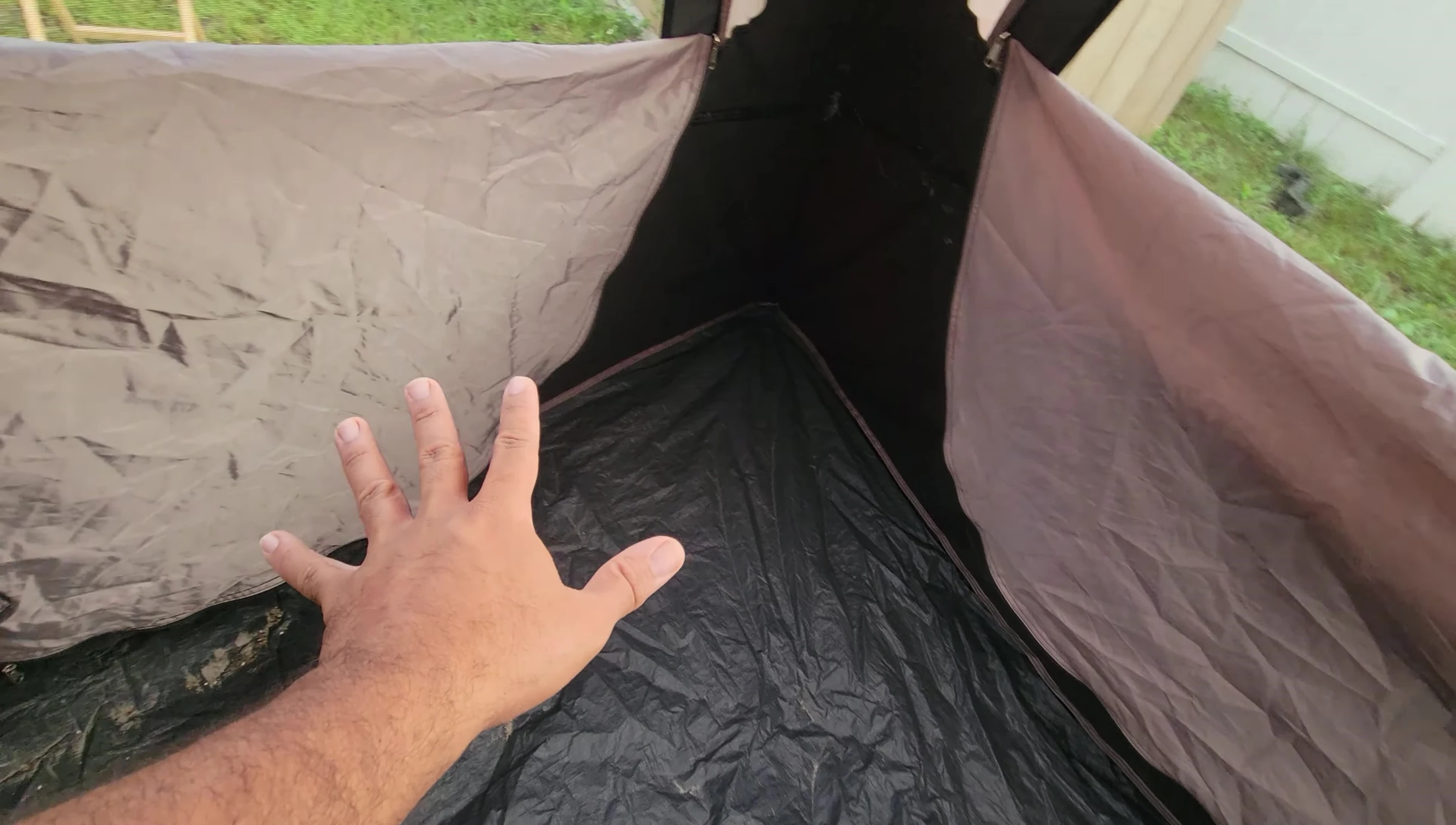 The reviewer demonstrating the interior space of the tent, showing several sleeping bags comfortably fitted.