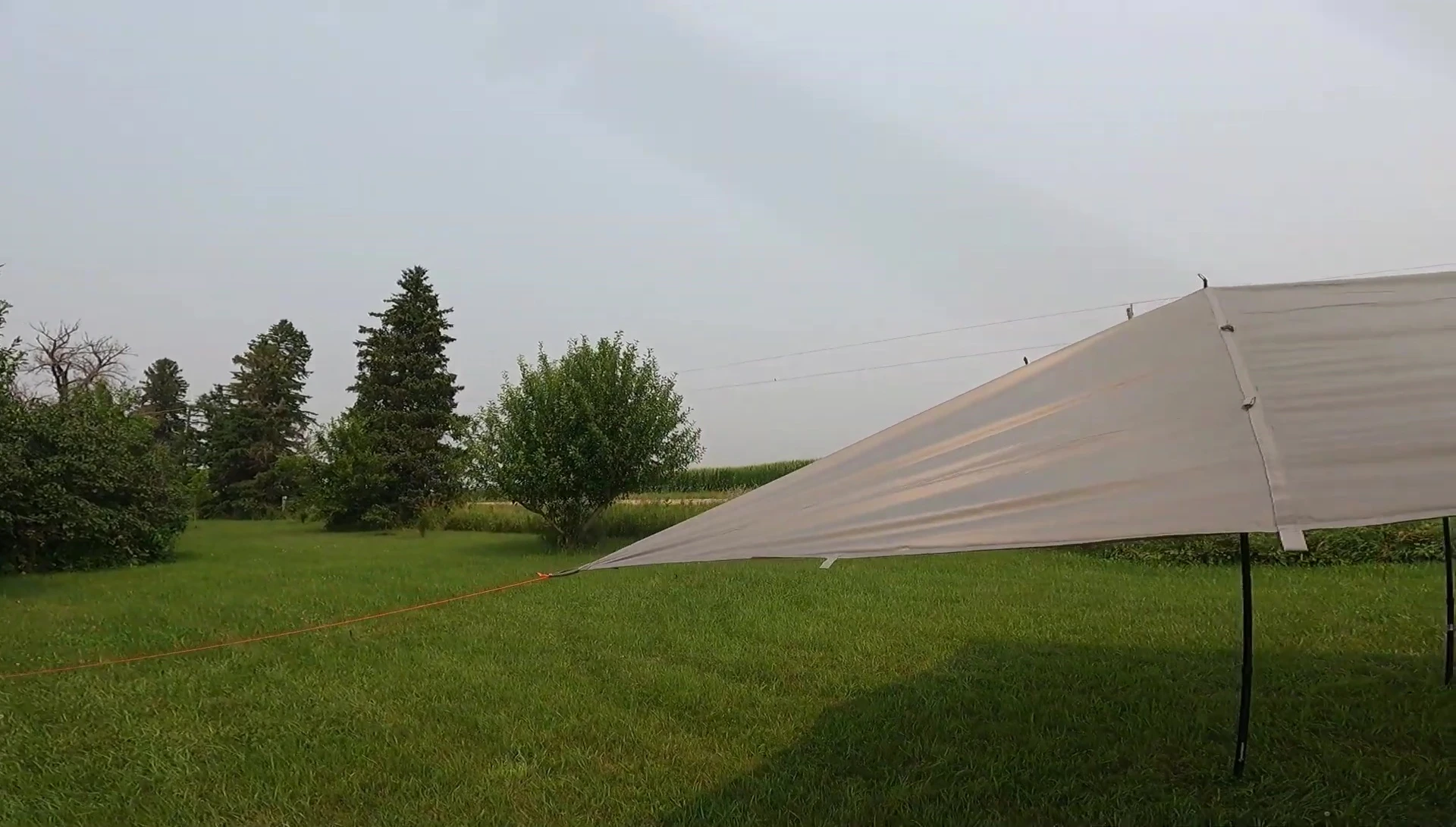 The tarp set up with four poles.