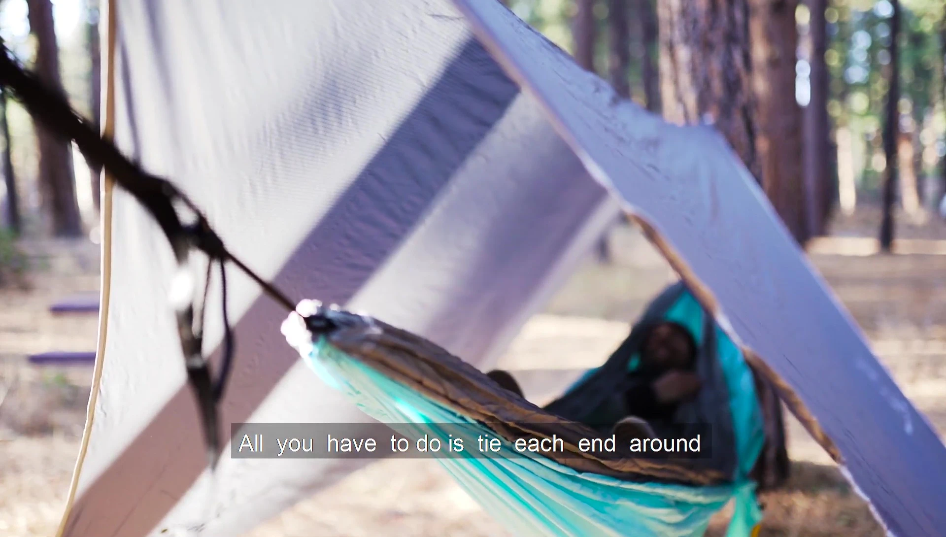 Person tying the tarp to a tree