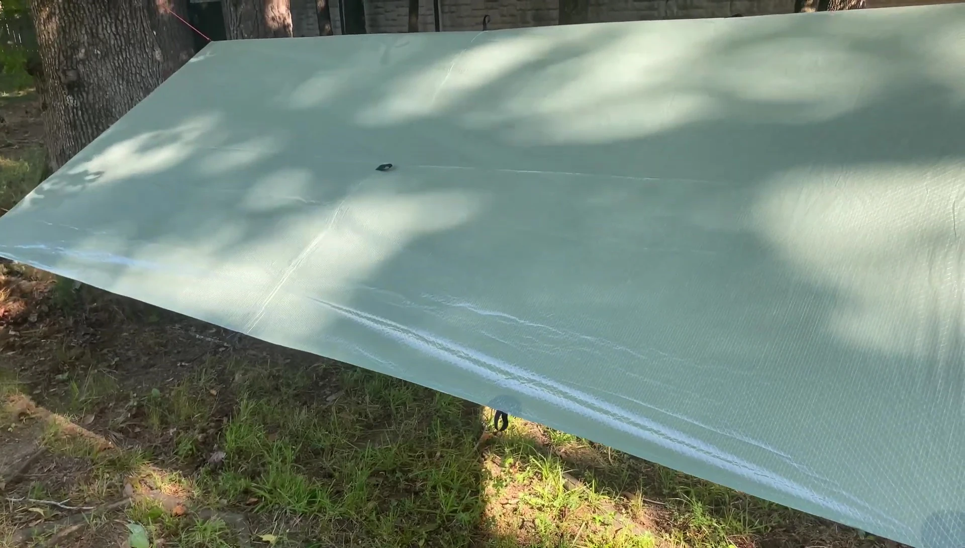 The tarp slightly waving in the wind with minimal tension