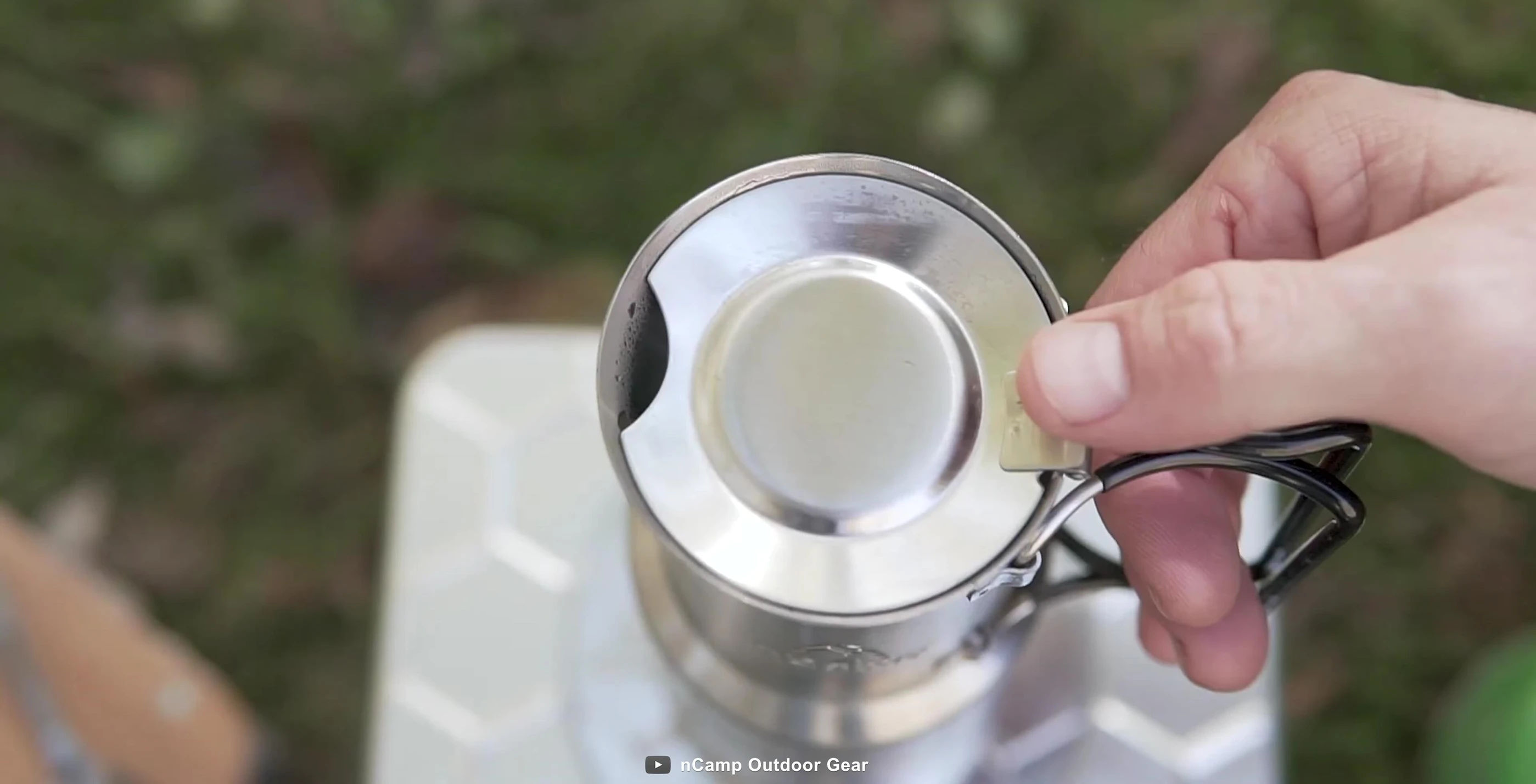 The coffee maker compared to a water bottle to showcase its compact size.