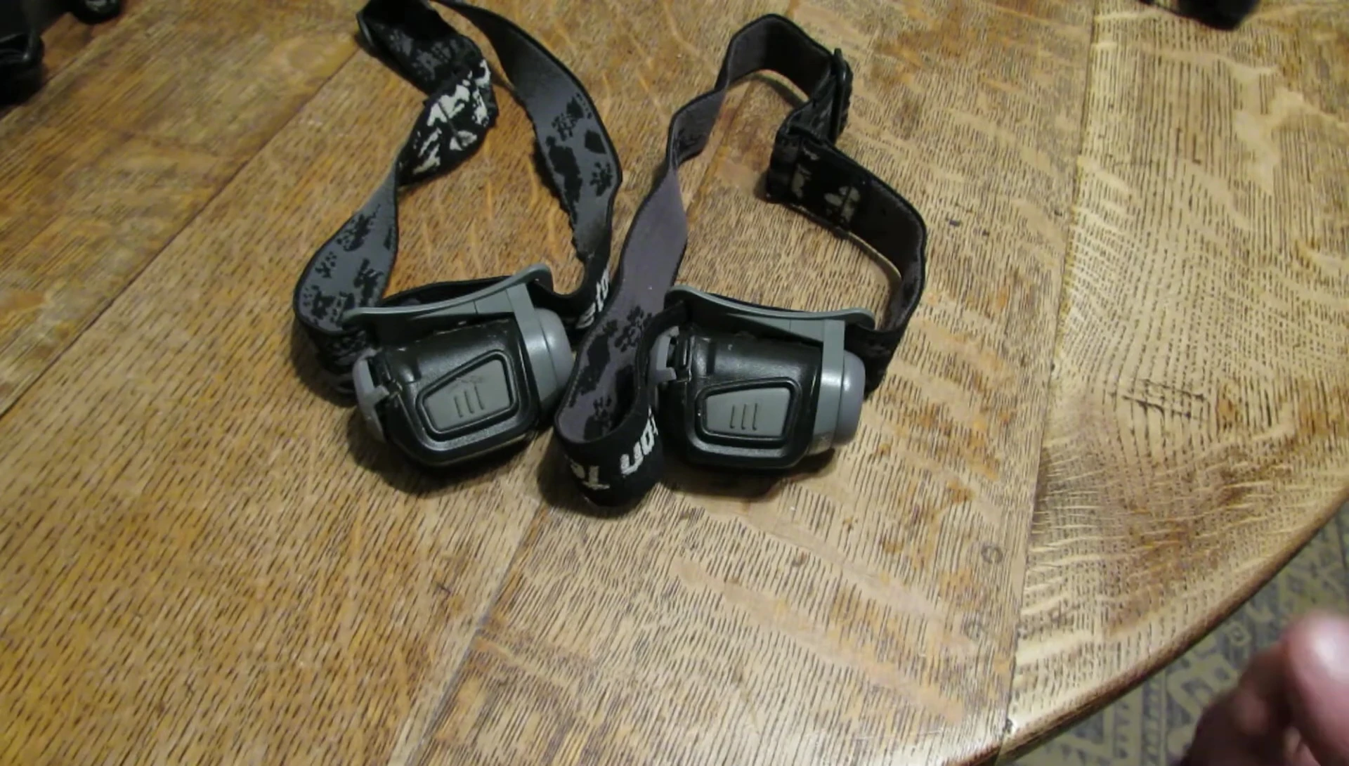 Close-up of two Princeton Tec Remix headlamps showing the broken battery door clips.