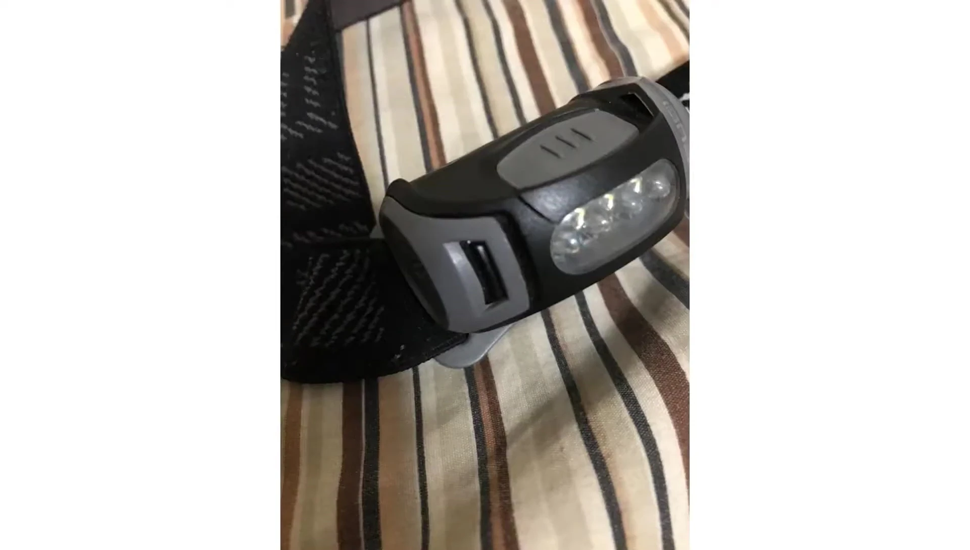 Close-up of an intact battery door clip on a Princeton Tec headlamp.