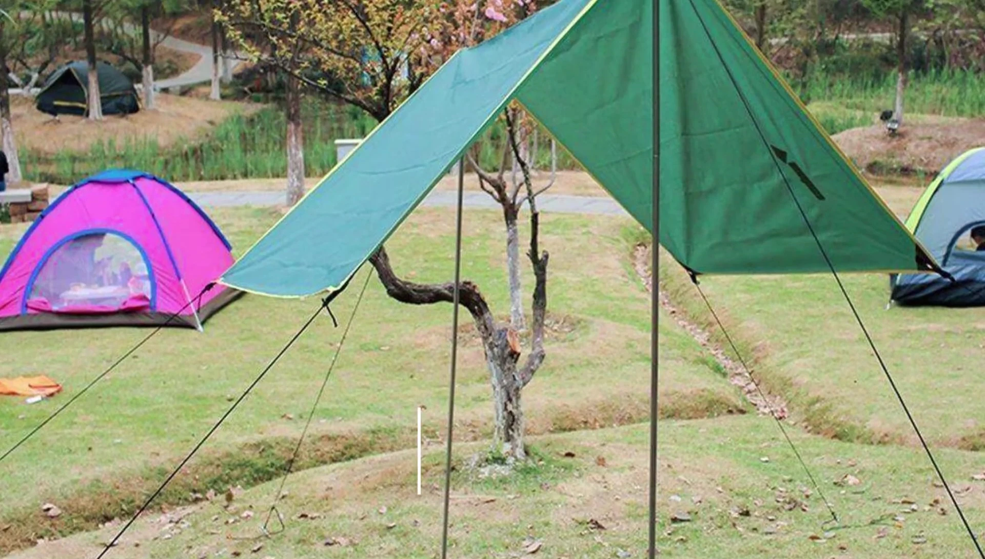 A large tarp being adjusted to fit a tent, showing excess material.