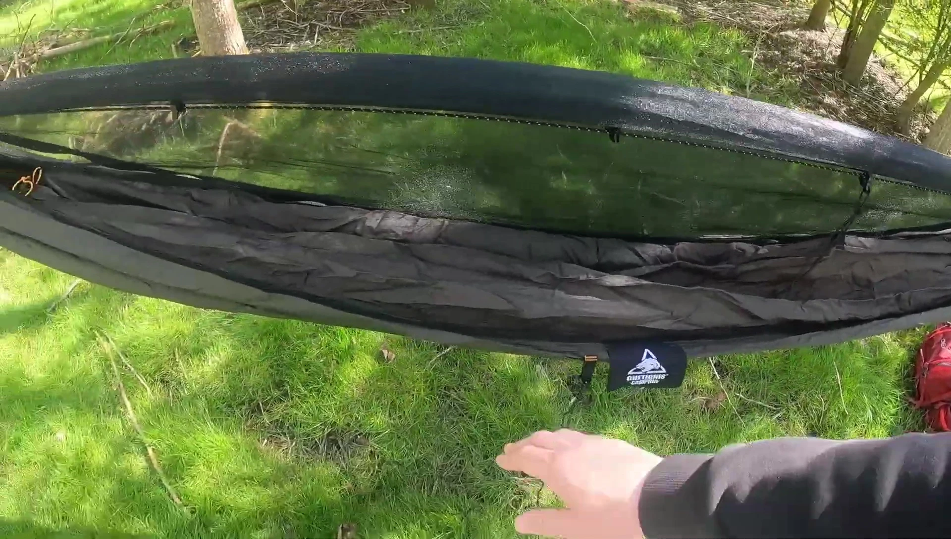 Person relaxing in the hammock with bug net