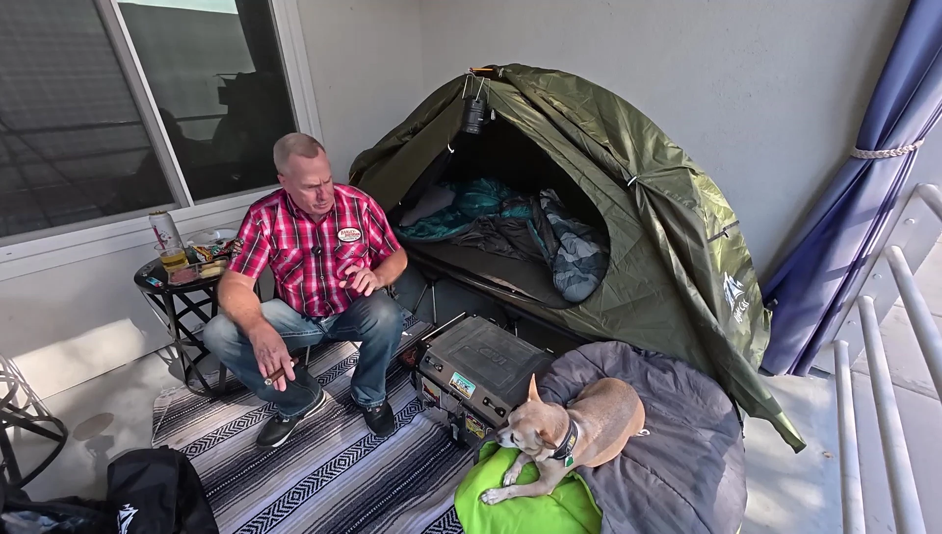 The speaker showing the cot and tent packed on his motorcycle.