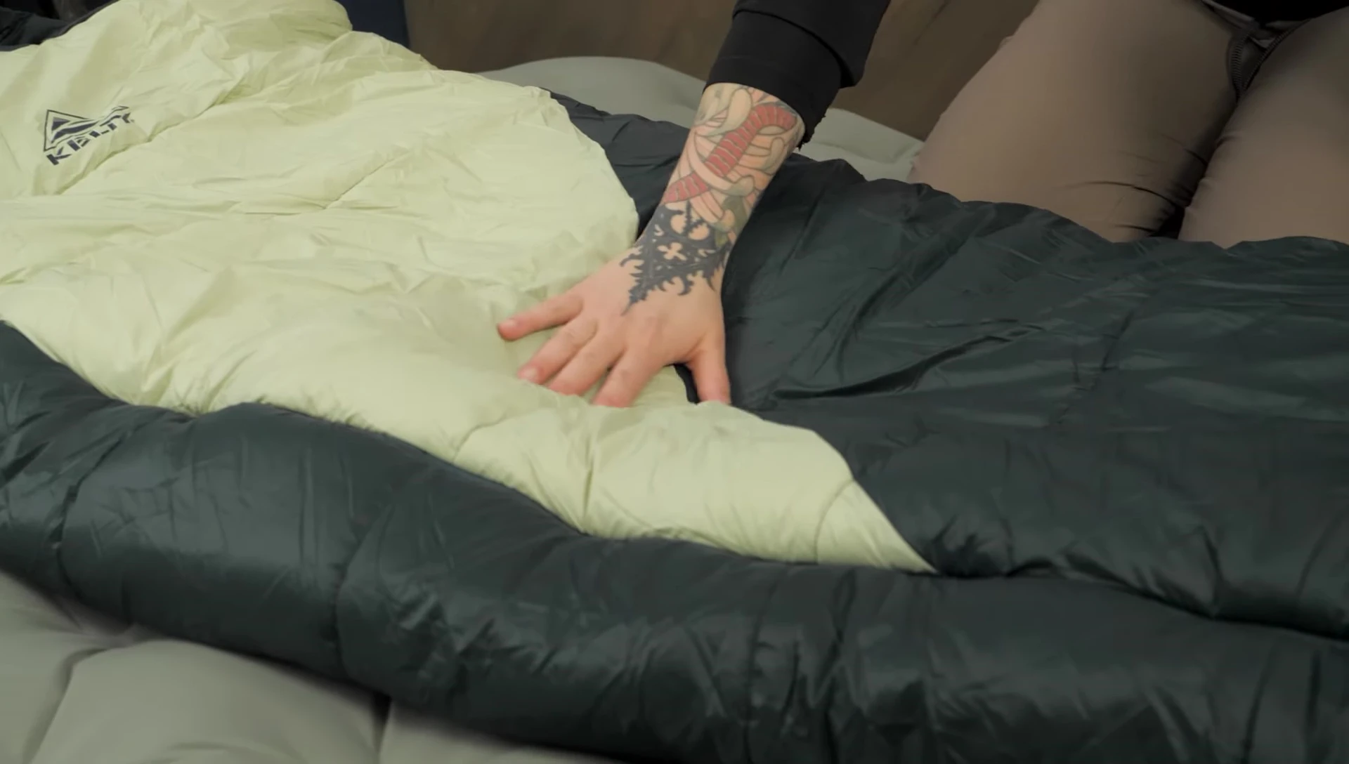 Person holding and showcasing the sleeping bag