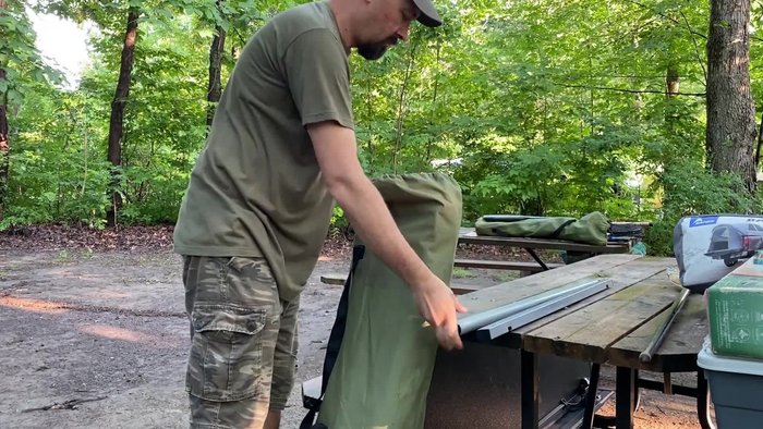 Take the cot out of the bag, holding it in the middle for easier handling.