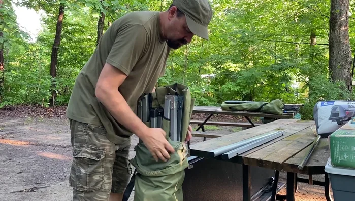 Take the cot out of the bag, holding it in the middle for easier handling.