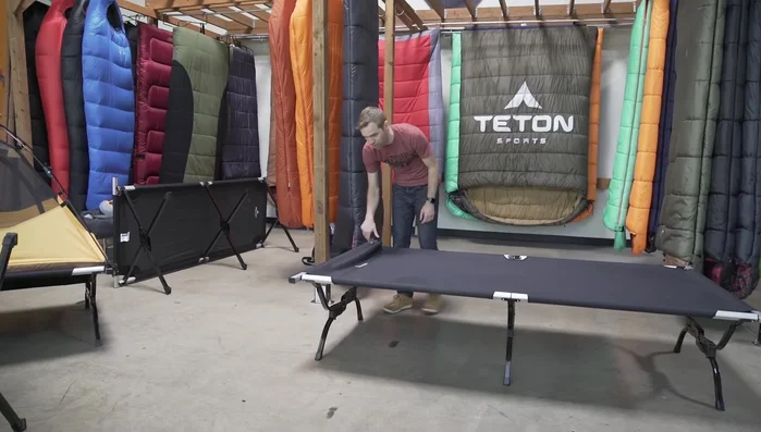 Fold the outer legs and roll the top of the cot to prevent pinching.