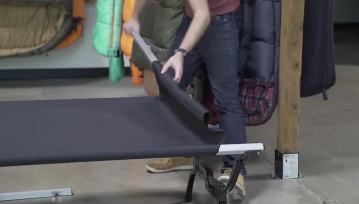 Fold the outer legs and roll the top of the cot to prevent pinching.