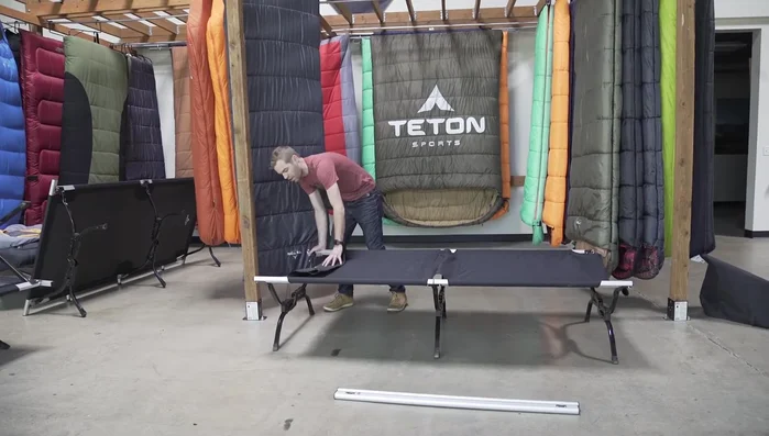Push down on each leg to help seat the leg into its bushing and wings, ensuring the cot is the correct width.