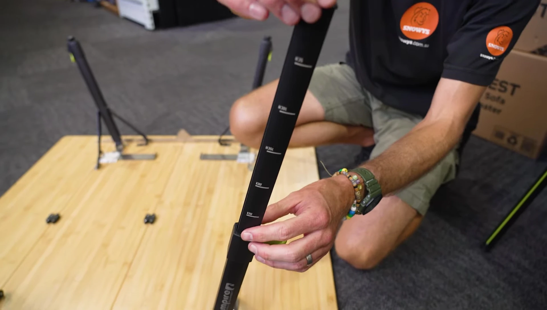 Adjusting the legs of the table to its maximum height.