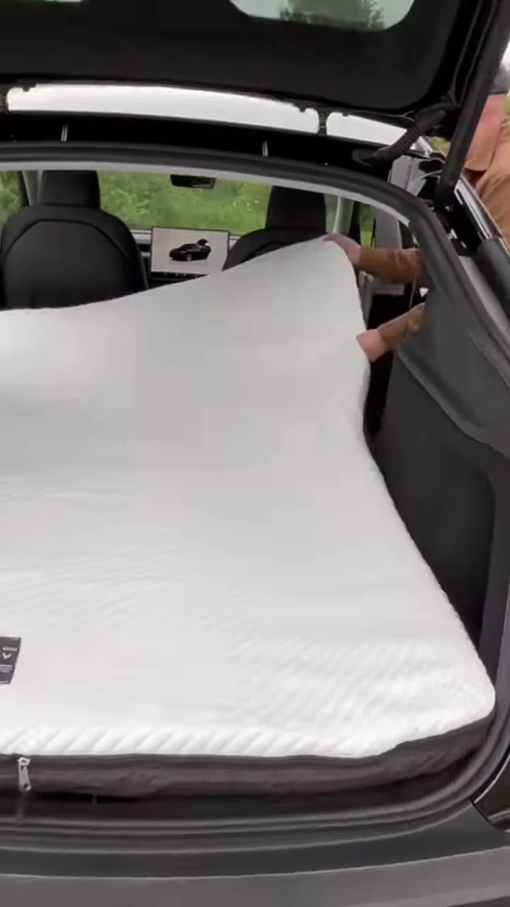Someone inflating the mattress inside the car.