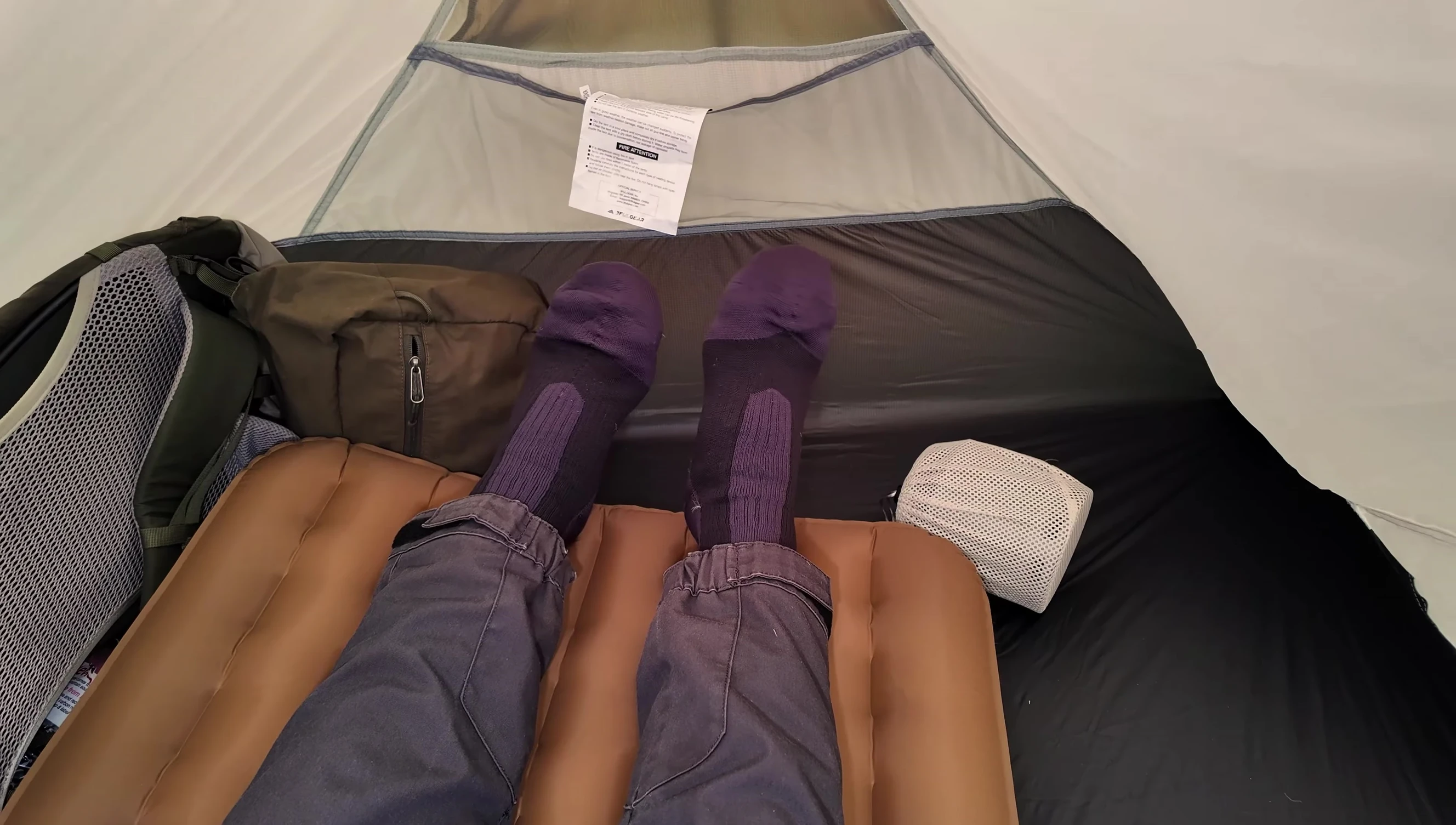 The reviewer demonstrating the tent's interior space with the pillow.