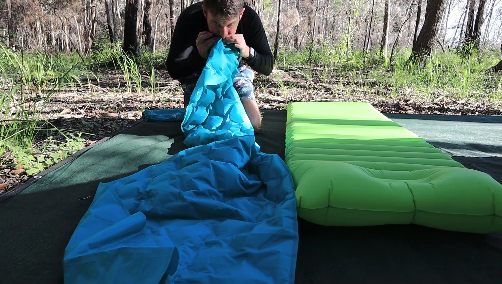 Person inflating the thin sleeping pad using breaths.