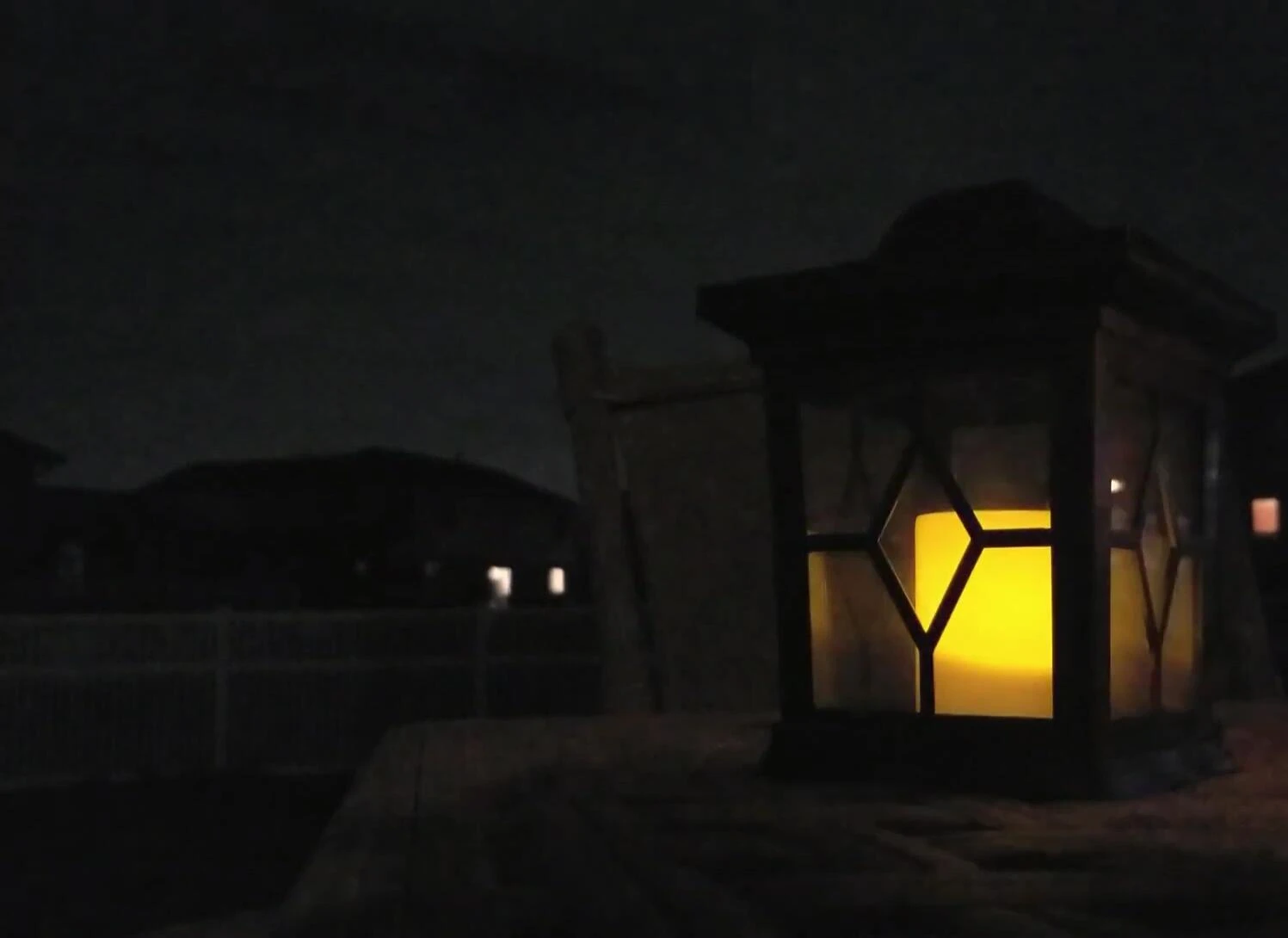Lantern sitting on a tabletop, providing soft ambient light.