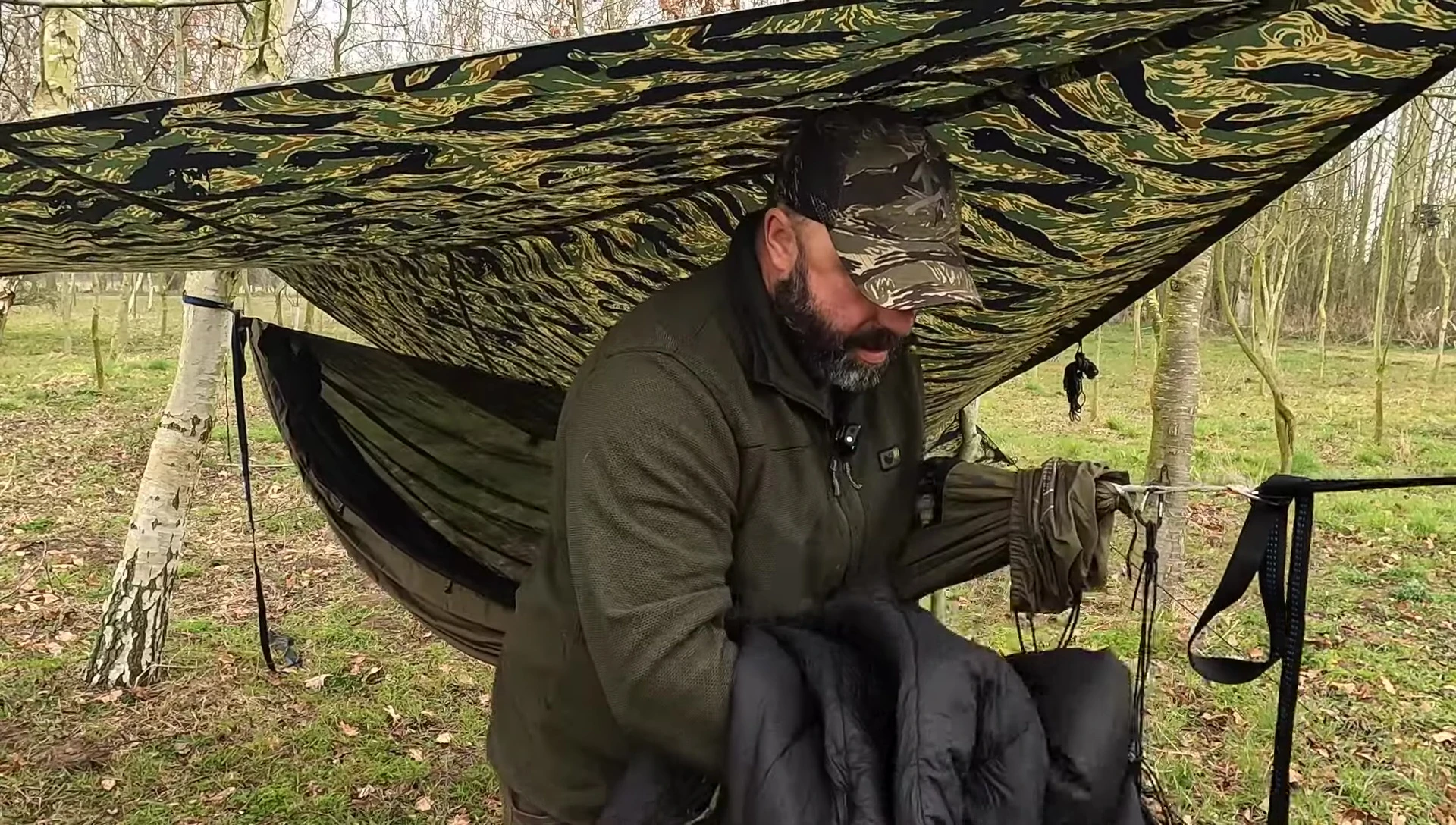 The reviewer showing how to fasten the underquilt to the hammock