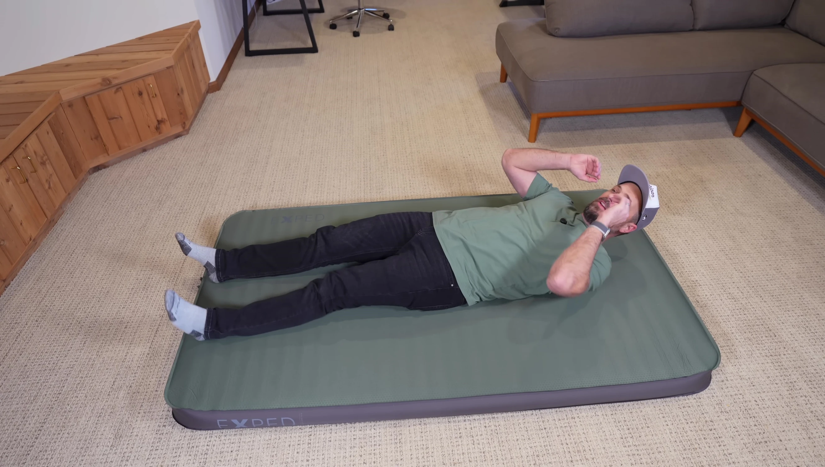 The reviewer demonstrates the size of the mat compared to his body size.