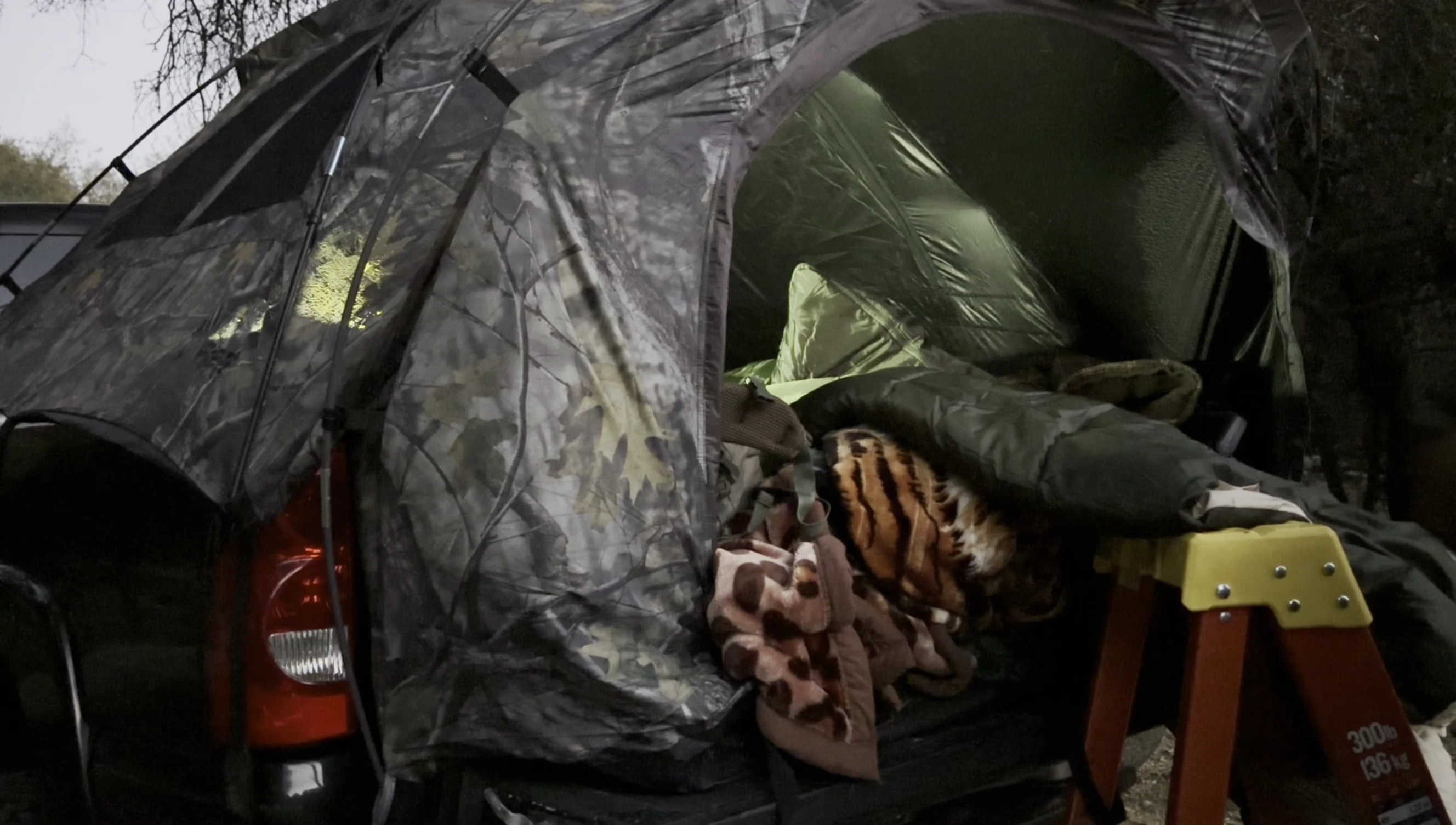 The sleeping bag being prepared for use in a truck bed tent